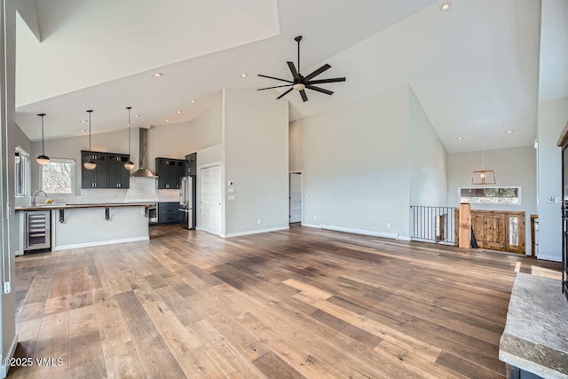 2900 June Creek Trl Unit B, Avon, CO 81620 - unfurnished living room with high vaulted ceiling, hardwood / wood-style floors, ceiling fan, wine cooler, and a baseboard radiator
