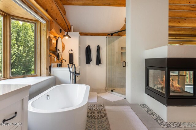 bathroom featuring vanity, tile patterned flooring, rustic walls, and a healthy amount of sunlight