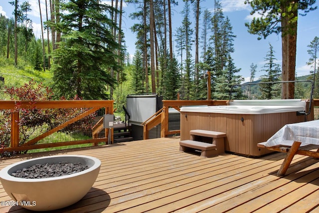 deck featuring a hot tub and a fire pit