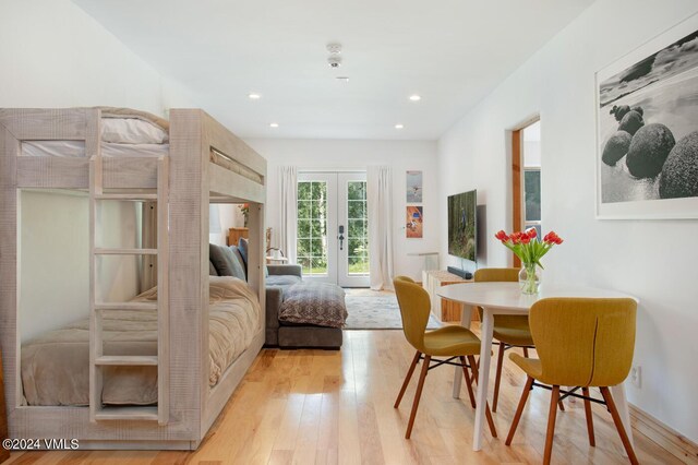 bedroom featuring access to outside, light hardwood / wood-style floors, and french doors