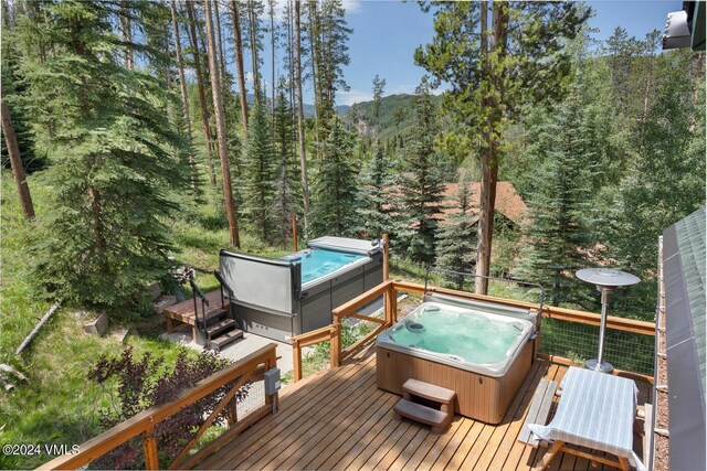 deck featuring an outdoor hot tub