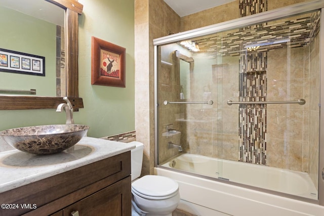 full bathroom featuring vanity, toilet, and combined bath / shower with glass door