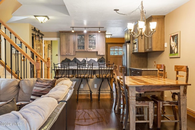 dining area with dark wood-type flooring and a chandelier