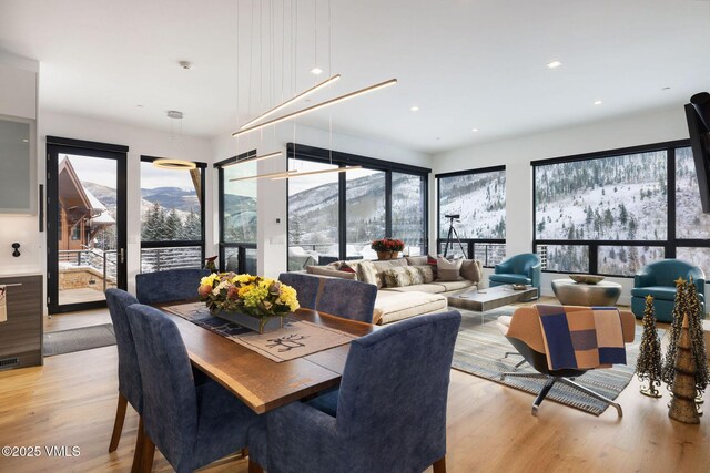 dining area with a wealth of natural light, a mountain view, and light wood-type flooring