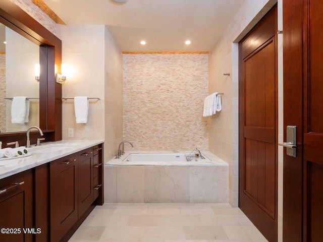 full bathroom with vanity, a garden tub, recessed lighting, tile walls, and tile patterned floors