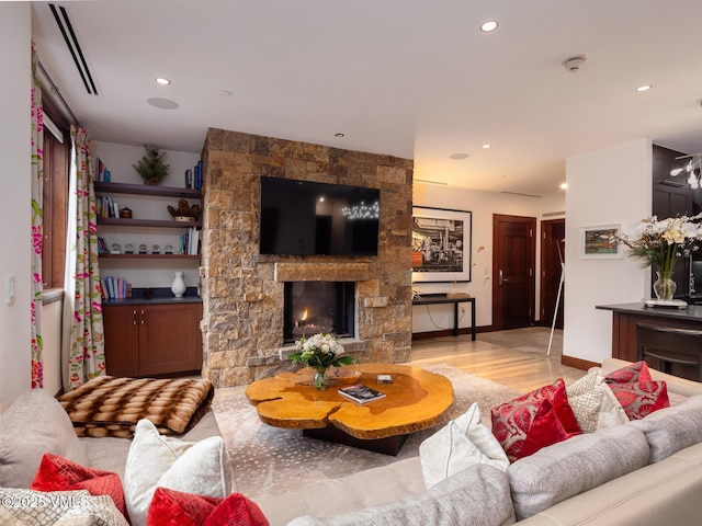 living area featuring recessed lighting, a fireplace, light wood-type flooring, and baseboards