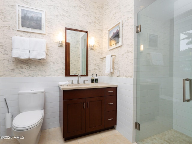 bathroom with vanity, wallpapered walls, a shower stall, wainscoting, and toilet