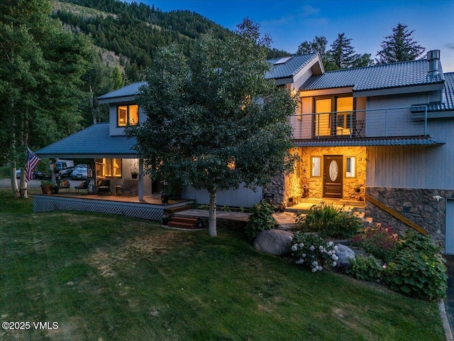 780 Deer Blvd, Avon, CO 81620 - rear view of house with a lawn, a balcony, and stone siding