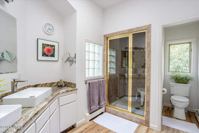 780 Deer Blvd, Avon, CO 81620 - bathroom featuring baseboard heating, a shower stall, wood finished floors, and double vanity