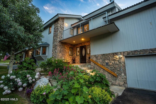 780 Deer Blvd, Avon, CO 81620 - doorway to property featuring stone siding, a balcony, and an attached garage