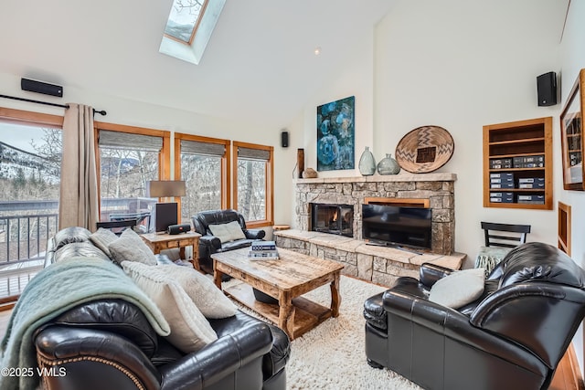 living room featuring a high ceiling, a skylight, and a stone fireplace