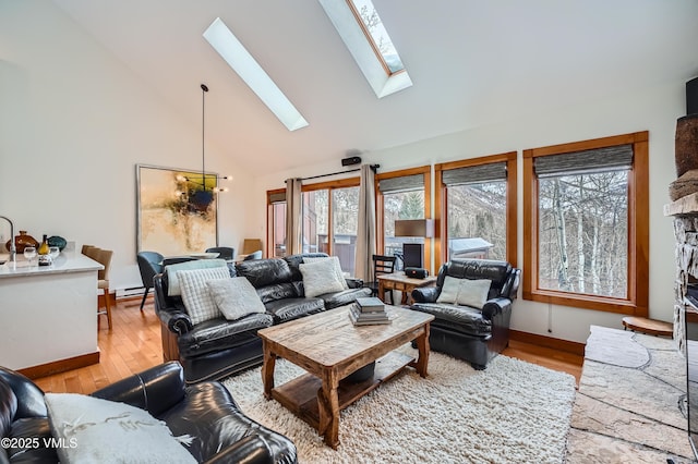 living room with light wood-type flooring, a skylight, high vaulted ceiling, and a baseboard radiator