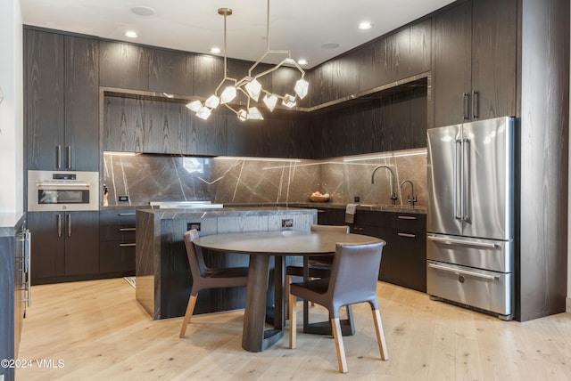 kitchen featuring dark brown cabinetry, stainless steel appliances, and decorative backsplash