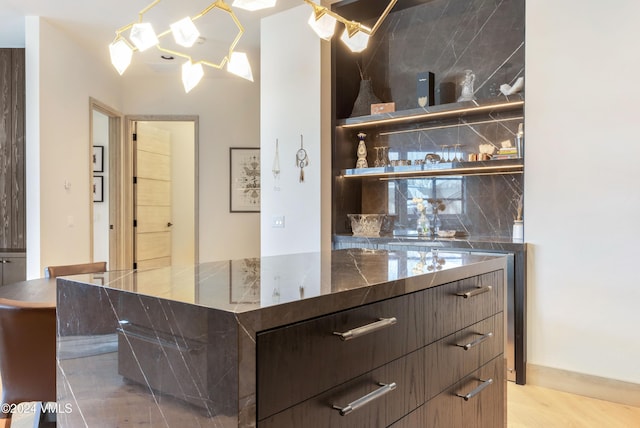 bar featuring dark brown cabinetry and light hardwood / wood-style flooring