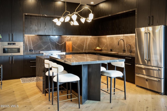 295 Main St Unit R-201, Edwards, CO 81632 - kitchen with appliances with stainless steel finishes, modern cabinets, decorative backsplash, and a center island
