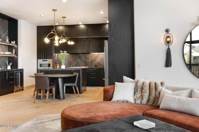 living room featuring light hardwood / wood-style floors, beverage cooler, and a chandelier