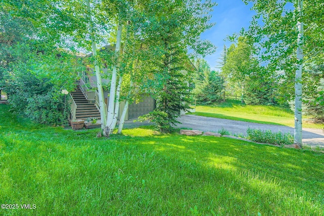 8 Charolais Cir, Edwards, CO 81632 - view of green lawn with driveway, stairs, and an attached garage