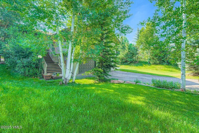 8 Charolais Cir, Edwards, CO 81632 - view of green lawn with driveway, stairs, and an attached garage