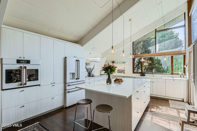 8 Charolais Cir, Edwards, CO 81632 - kitchen featuring white appliances, dark wood-type flooring, a kitchen island, light countertops, and white cabinetry