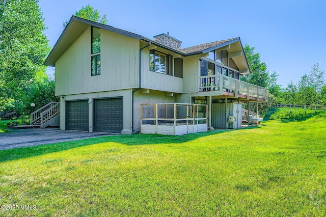 8 Charolais Cir, Edwards, CO 81632 - rear view of house featuring a garage, asphalt driveway, a yard, and a chimney