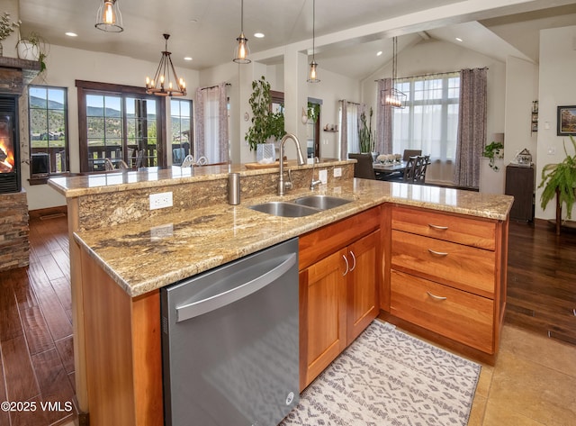 75 Aster Ct, Eagle, CO 81631 - kitchen featuring dishwasher, a chandelier, a glass covered fireplace, brown cabinets, and light stone countertops