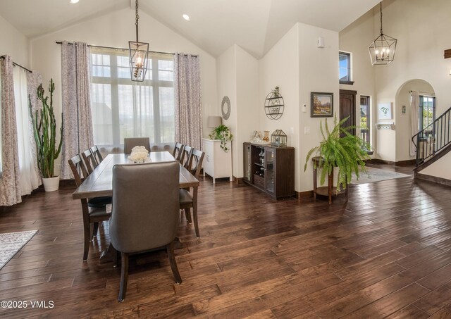 75 Aster Ct, Eagle, CO 81631 - dining room featuring high vaulted ceiling, arched walkways, a chandelier, stairway, and dark wood-style flooring