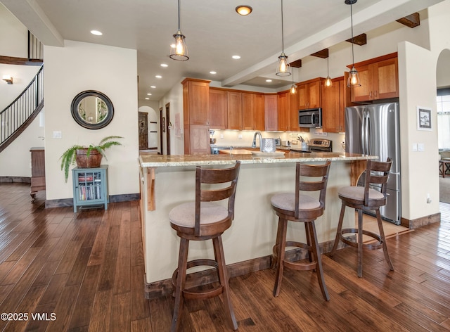 75 Aster Ct, Eagle, CO 81631 - kitchen with appliances with stainless steel finishes, dark wood-style flooring, light stone countertops, recessed lighting, and hanging light fixtures