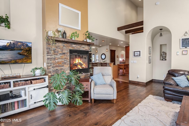 75 Aster Ct, Eagle, CO 81631 - living area with wood-type flooring, a fireplace, a towering ceiling, and arched walkways