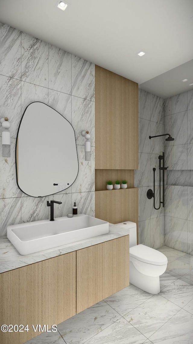 bathroom featuring toilet, recessed lighting, a sink, marble finish floor, and a tile shower