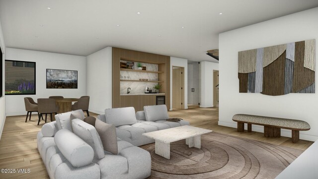 living area with indoor wet bar, light wood-style flooring, and baseboards