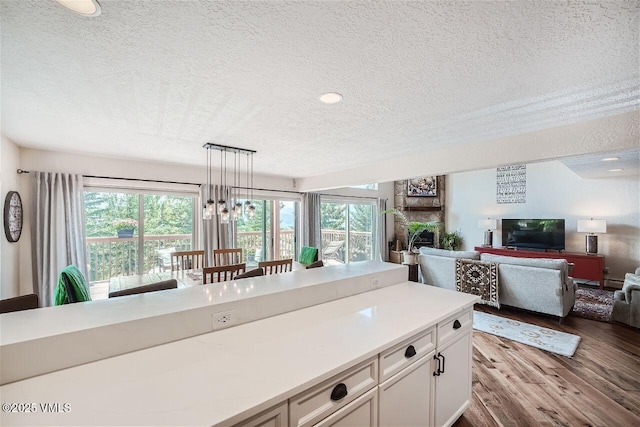 3078 Wildridge Rd Unit D, Avon, CO 81620 - kitchen with a textured ceiling, dark wood-style flooring, light countertops, white cabinetry, and open floor plan