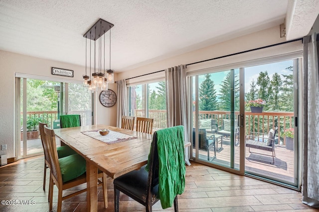 3078 Wildridge Rd Unit D, Avon, CO 81620 - dining space with a textured ceiling, hardwood / wood-style flooring, plenty of natural light, and a chandelier