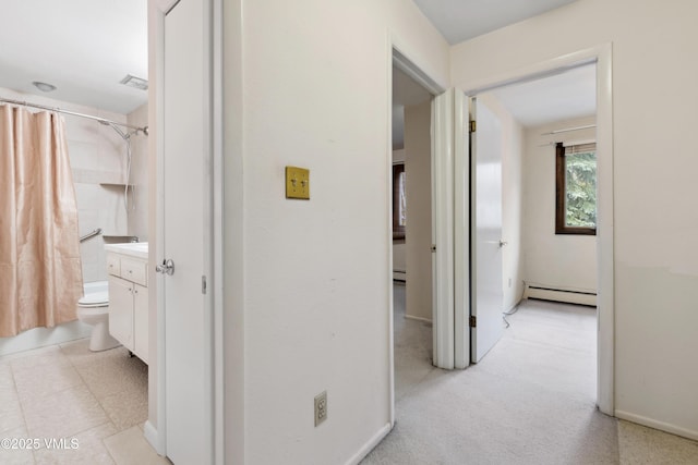 hallway featuring a baseboard heating unit and visible vents