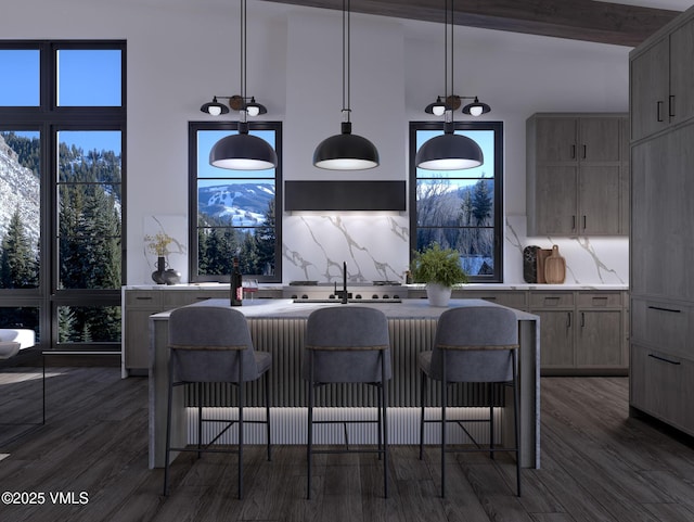 kitchen with backsplash, a kitchen bar, dark wood-type flooring, and a sink