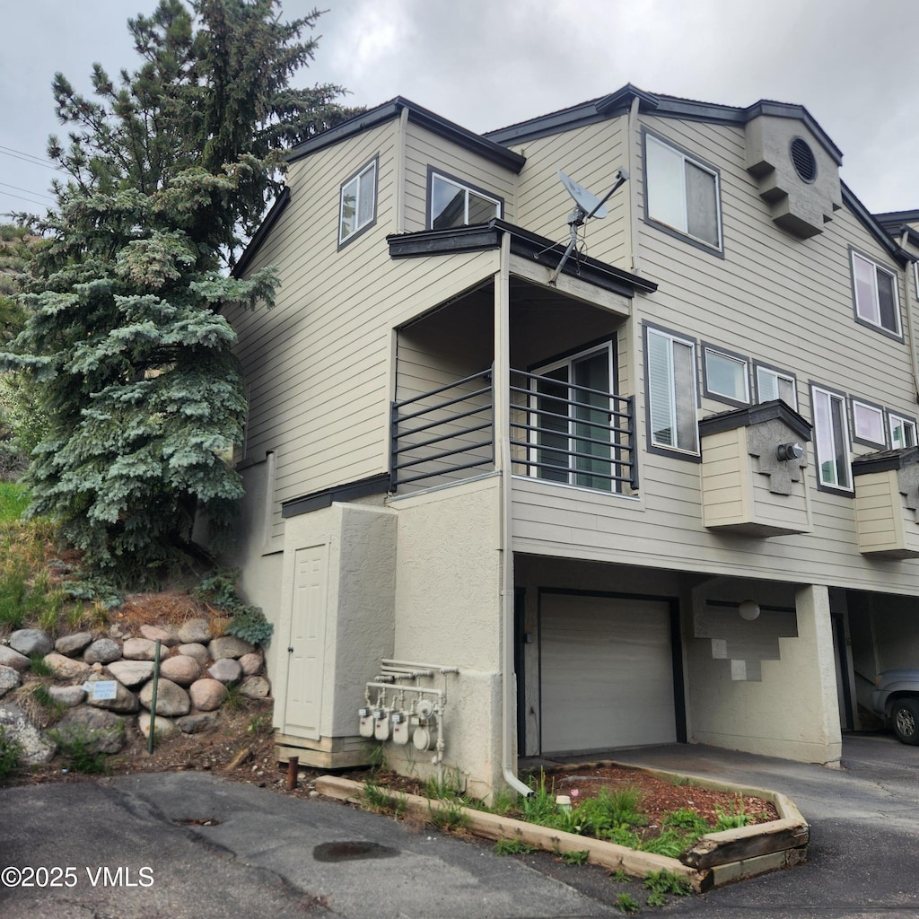 600 Nottingham Rd Unit 15, Avon, CO 81620 - view of side of property with a garage, a balcony, driveway, and stucco siding