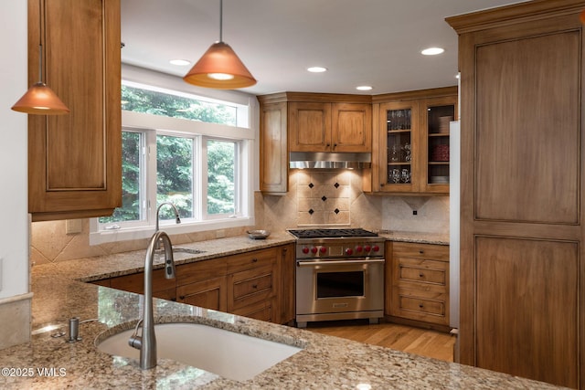 4240 Spruce Way, Vail, CO 81657 - kitchen with premium range, under cabinet range hood, brown cabinets, light stone countertops, and recessed lighting