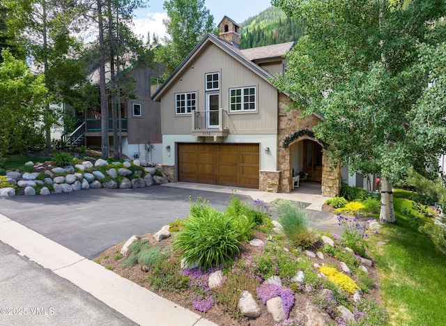 4240 Spruce Way, Vail, CO 81657 - view of front of house featuring stone siding, a garage, and asphalt driveway