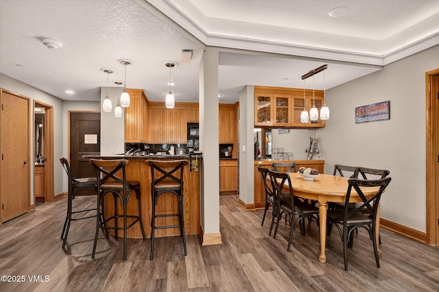 120 Offerson Unit 5160, Beaver Creek, CO 81620 - kitchen featuring wood finished floors, dark countertops, a breakfast bar, black microwave, and brown cabinets