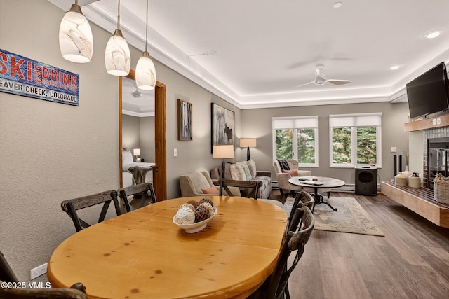 120 Offerson Unit 5160, Beaver Creek, CO 81620 - dining room featuring a glass covered fireplace, wood finished floors, a tray ceiling, ceiling fan, and recessed lighting