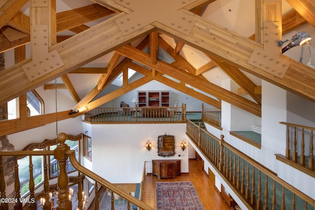 hallway featuring wood-type flooring, beam ceiling, and high vaulted ceiling