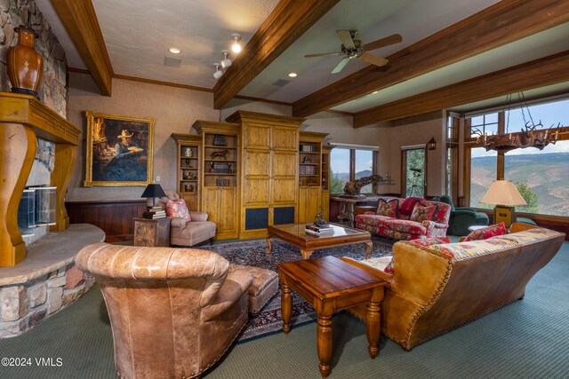 carpeted living room featuring ceiling fan, a fireplace, and beam ceiling