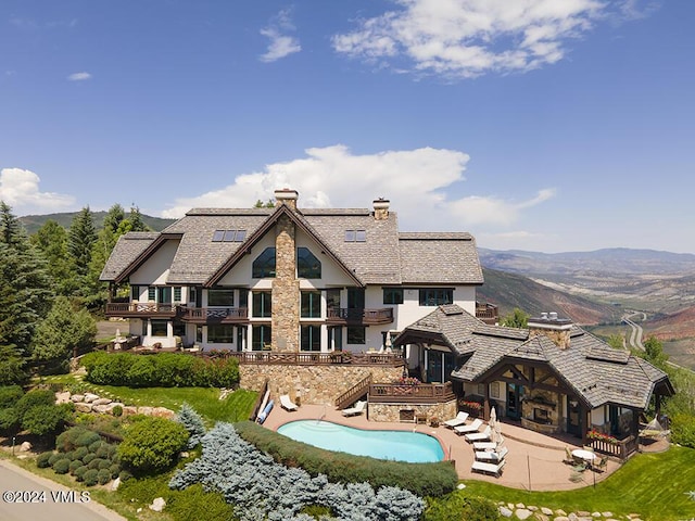 back of house with a mountain view and a patio area