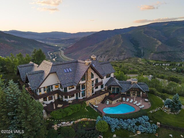 aerial view at dusk featuring a mountain view