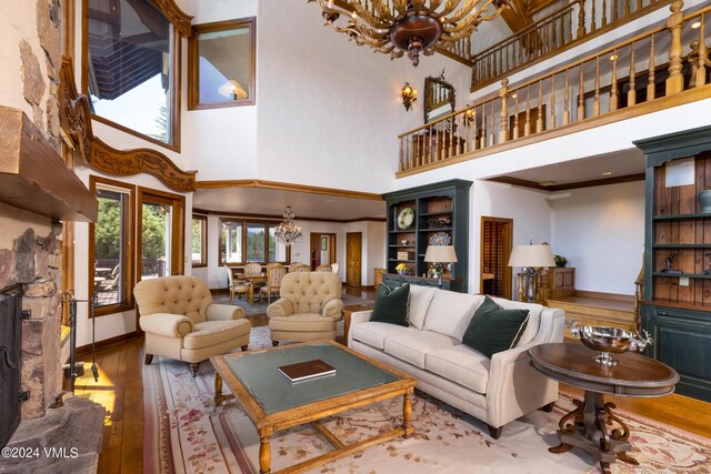 living room featuring hardwood / wood-style flooring, a towering ceiling, and a chandelier