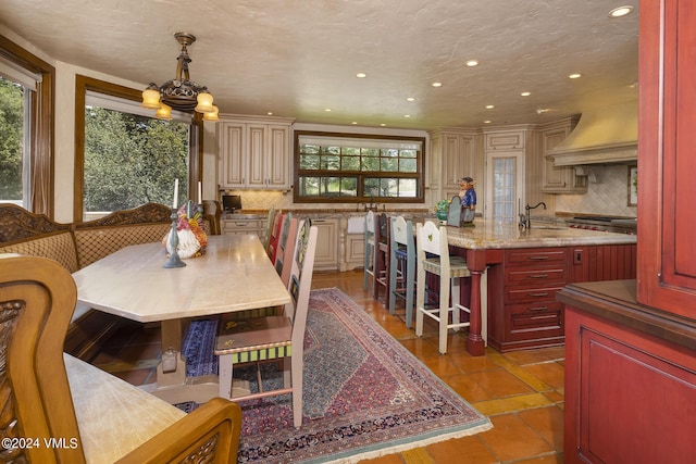 tiled dining room featuring sink, a notable chandelier, and a textured ceiling