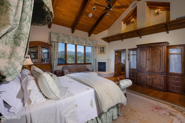 bedroom with high vaulted ceiling, beamed ceiling, a mountain view, wooden ceiling, and light hardwood / wood-style flooring