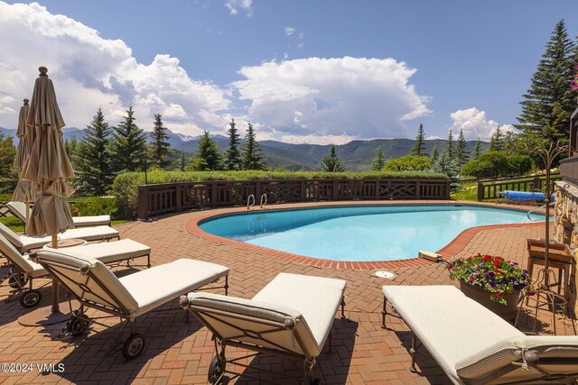 view of pool with a mountain view and a patio area