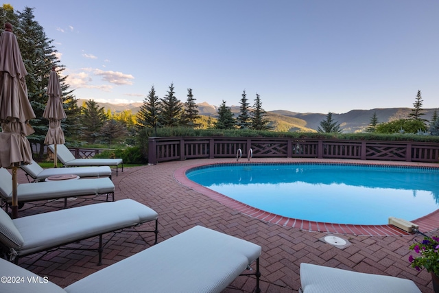 view of swimming pool featuring a mountain view and a patio area