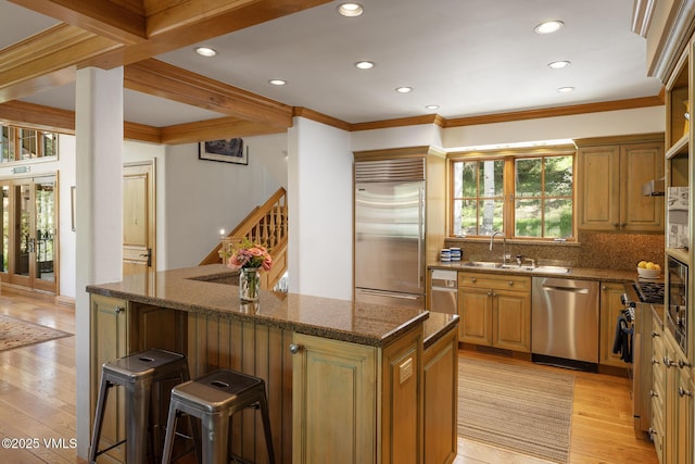 416 Forest Rd Unit A, Vail, CO 81657 - kitchen with stainless steel appliances, a kitchen island, a kitchen bar, light wood finished floors, and recessed lighting