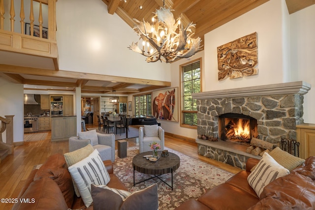 416 Forest Rd Unit A, Vail, CO 81657 - living area with light wood-type flooring, a chandelier, a wooden ceiling with exposed beams, a fireplace, and a high ceiling